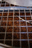 Grains de café torréfiés artisanalement dans les tiroirs de la brûlerie Verlet